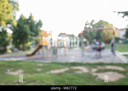 Un cursore situato sulla sabbia in estate. Sfocati e immagine sfocata per lo sfondo del parco giochi, attività a parco pubblico. Altalene per bambini sulla moderna Co Foto Stock