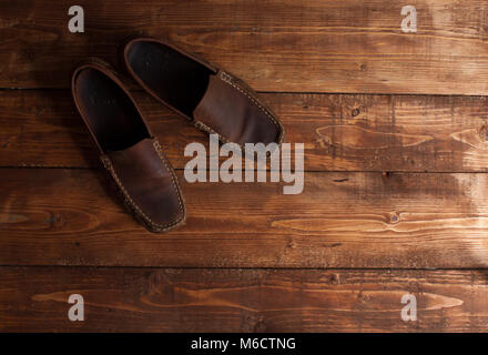 Brown mocassini su uno sfondo di legno. Foto Stock