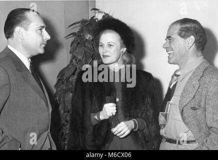 Roberto Rossellini (sinistra), famoso Italian motion picture director, colloqui con attrice cinematografica Joan Caulfield e regista Frank Capra a un pranzo in suo onore a Paramount Studios. Hollywood, CA, 1/31/49. Foto Stock