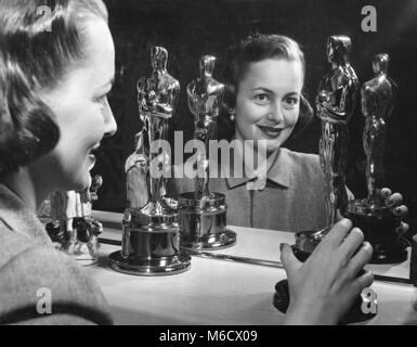 Schermo attrice Olivia de Havilland con i suoi due premi Oscar per le rappresentazioni in 'a ciascuno il suo' nel 1946 e 'l'ereditiera' nel 1950. Brentwood, CA, marzo 1950. Foto Stock