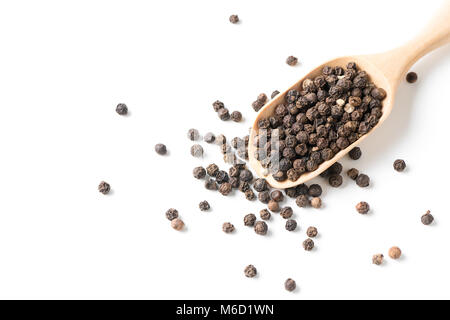 Asciugare il pepe nero su legno scoop isolato su sfondo bianco con copia spazio. Spezie ed erbe calde concept Foto Stock