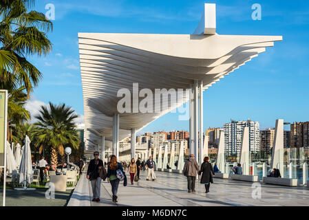 Malaga, Spagna - 7 Dicembre 2016: Le persone sono a piedi lungo il terrapieno (Paseo Del Muelle Dos Promenade) che si estende attraverso la porta sotto un constr Foto Stock