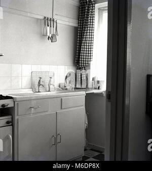 Anni sessanta, foto storiche che mostra una piccola cucina compatta o mini-cucina in un appartamento in una casa residenziale, Inghilterra, Regno Unito. Foto Stock