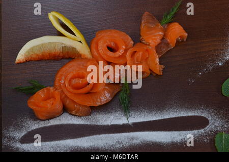 Affumicato tagliato o salato salmone fresco con limone ed aneto messa a fuoco selettiva. Il cibo del ristorante. Piatto di pesce, banchetti e catering servito piastra in legno rustico wit Foto Stock