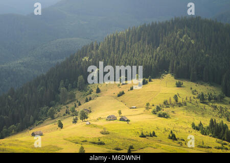 Vista dei Carpazi del campo Highland con i cacciatori di vecchie case sulla collina accanto alla struttura di pelliccia di foreste e montagne Foto Stock