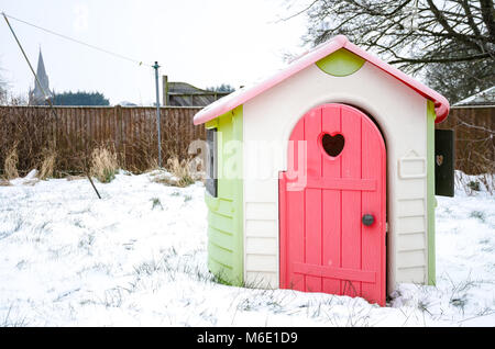 Un bambino giocattolo casa illustrata nel giardino sul retro in un giorno di neve. Foto Stock