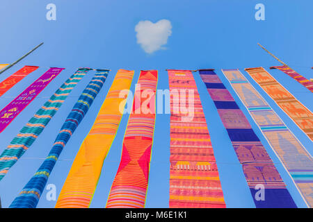 Abstract il vento che soffia bandiere colorate con il blu del cielo cloud, cuore Sfondo nuvola.La tradizione di merito in Thailandia, proprietà pubblica. Foto Stock