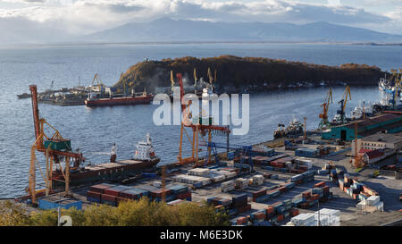 Vista panoramica di navi al molo, gru portuali sul porto commerciale Petropavlovsk-Kamchatsky città sulle rive della Baia Avacha in Oceano Pacifico. Foto Stock