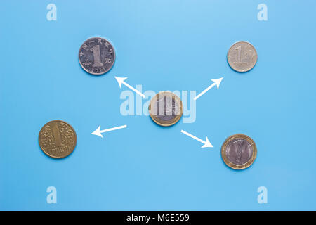 Cambio valuta concetto. diverse monete su sfondo blu Foto Stock