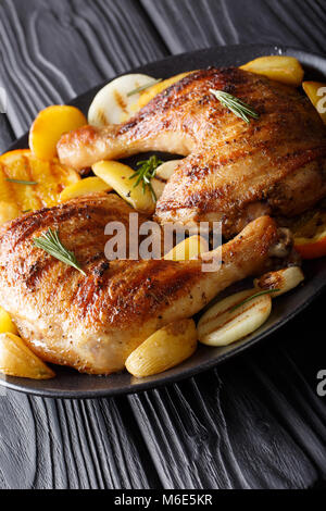 Deliziosi barbecue le cosce di pollo alla griglia con frutta e verdura close-up su una piastra sul piano verticale. Foto Stock