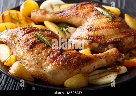 Pollo alla griglia della gamba con le arance, le cipolle e le patate macro su una piastra orizzontale. Foto Stock