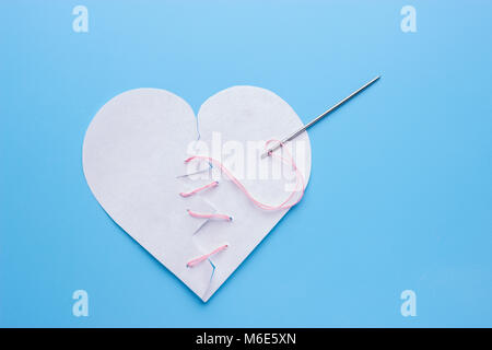 La guarigione cuore spezzato. ago con filo rosa Foto Stock
