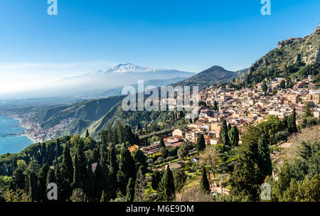 Una vista panoramica di Taormina e Giardini Naxos e sul Monte Etna in Sicilia, Italia. Foto scattata da Via Teatro Greco di Taormina. Foto Stock