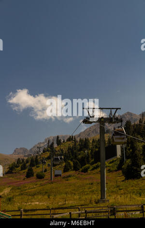 Pilone e pod di cavo auto con montagne in estate. Shymbulak Ski Resort Hotel di Almaty, Kazakhstan, in Asia. Foto Stock