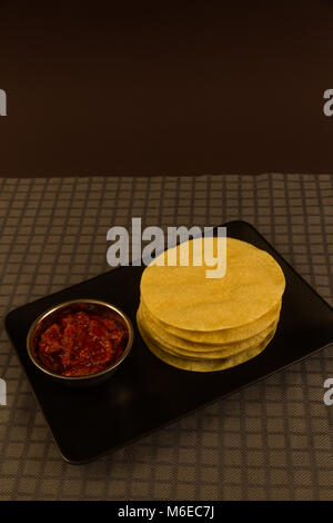 Indian poppadums impilati con coppa di calce pickle e fettine di lime Foto Stock