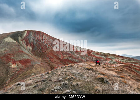 Fotografo di natura in sorprendente a strisce rosse montagne Foto Stock