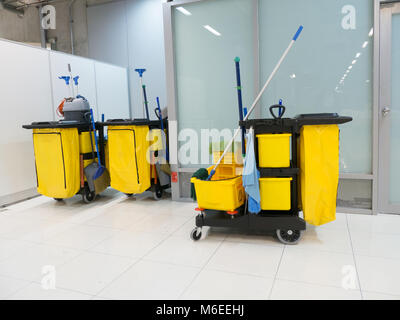 Carrello di pulizia nella stazione. Strumenti per la pulizia del carrello e mop gialla di attesa della benna per la pulizia.benna e set di attrezzature per la pulizia in aeroporto in ufficio. Foto Stock