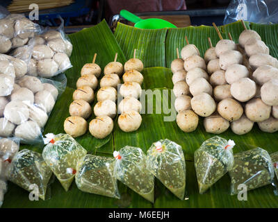 Salsicce fritte fritte e polpette di carne di maiale sulla banana leaf pronti per la vendita in mercati freschi, Thailandia street food. Foto Stock