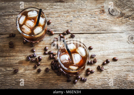 Nero Cocktail russo con la vodka e il liquore al caffè. In casa Boozy alcolica nero russo bere con i chicchi di caffè su sfondo di legno. Foto Stock