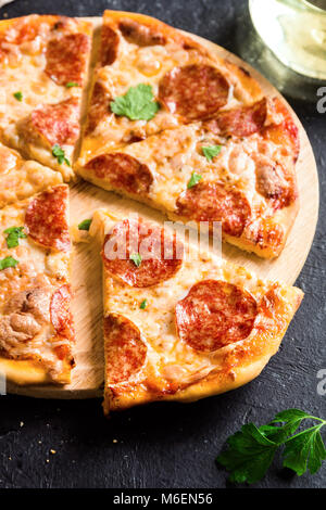 Salsiccia per Pizza Pizza - freschi fatti in casa la pizza con salsiccia per pizza, formaggio e salsa di pomodoro rustico in pietra nera sfondo con copia spazio. Foto Stock