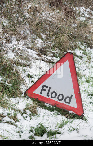 L'anomalia di un rosso allarme alluvione cartello stradale durante le nevi del 2018 'Bestia da est' - a Lostwithiel, Cornwall. Foto Stock