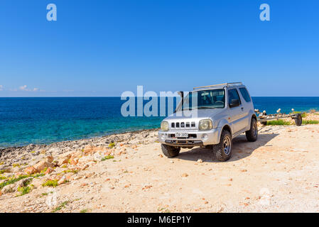Zante, Grecia - 1 Ottobre 2017: Suzuki Jimny auto parcheggiate in Porto Roxa, rocciosa e la spiaggia tranquilla sulla costa dell'isola di Zante. La Grecia Foto Stock