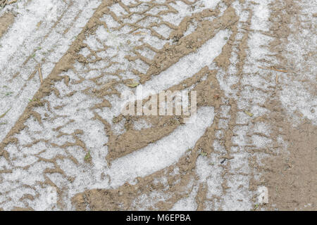 Il pneumatico del trattore le vie segna infilled con neve durante il 2018 'Bestia da est' cold snap. Foto Stock