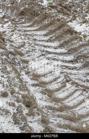 Il pneumatico del trattore le vie segna infilled con neve durante il 2018 'Bestia da est' cold snap. Foto Stock