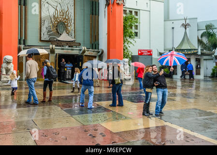 I turisti a portata di mano le stampe e firme di celebrità nella parte anteriore del Teatro Cinese, Hollywood Boulevard, L.A., California Foto Stock