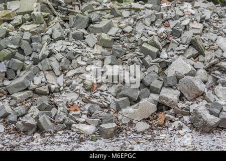 Pila di builder / macerie con una spolverata di neve presente. Metafora per la rotta in pezzi, a brandelli, rotte economia, frantumata in pezzi Foto Stock