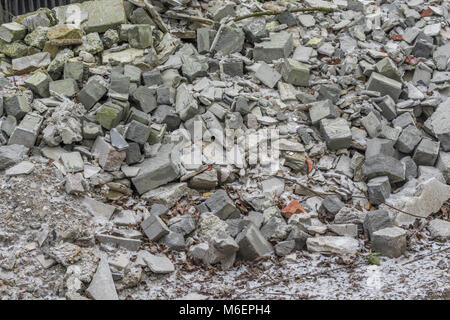 Pila di builder / macerie con una spolverata di neve presente. Metafora per la rotta in pezzi, a brandelli, rotte economia, frantumata in pezzi Foto Stock