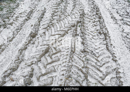 Coperta di neve il pneumatico del trattore le vie durante la 'bestia da est' - potenziale per distruggere ed agricola. Foto Stock