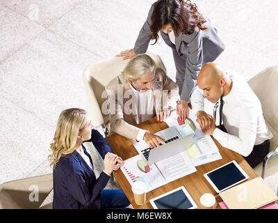 Multinazionale e multietnica dirigenti aziendali riunione in ufficio a discutere le prestazioni aziendali, ad alto angolo di visione. Foto Stock