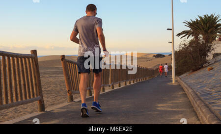 Uomo che corre sul lungomare a Maspalomas, Gran Canaria Island. Foto Stock