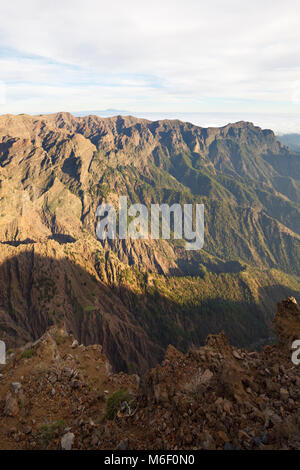 Vista sulla roccia grezza le pareti della Caldera de Taburiente da Roque de los Muchachos a La Palma, Spagna. Tenerife in background. Foto Stock