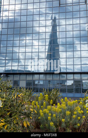 Un diverso e insolito angolo atmosferica o punto di vista di shard edificio per uffici nel centro di Londra si riflette in un grande bicchiere commercialor business Foto Stock