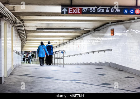 La città di New York, Stati Uniti d'America - 28 Ottobre 2017: la gente nella piattaforma della metropolitana di transito, il trasferimento in NYC stazione metropolitana sulla commutare con due donne musulmane a piedi Foto Stock