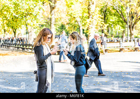 La città di New York, Stati Uniti d'America - 28 Ottobre 2017: Manhattan NYC Central park con persone in piedi sulla strada in autunno stagione autunnale con foglie cadute a terra e due Foto Stock