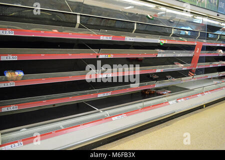 Post neve, bassa scorte sugli scaffali del supermercato in Tesco Fforestfach Foto Stock