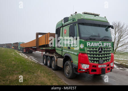 Il trasporto pesante i camion che trasportano un metallo per la costruzione di ponti per il 2018 Ely Bypass. Parcheggiato in layby in attesa di consegna. Carico più grande 150 Tonns (carico e carrello), 45m. Ferro battuto portato dal sud del Galles a Ely. Foto Stock