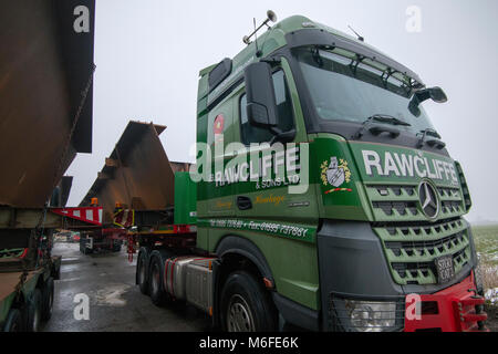 Il trasporto pesante i camion che trasportano un metallo per la costruzione di ponti per il 2018 Ely Bypass. Parcheggiato in layby in attesa di consegna. Carico più grande 150 Tonns (carico e carrello), 45m. Ferro battuto portato dal sud del Galles a Ely. Foto Stock