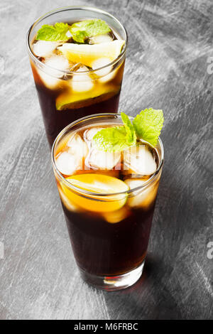 Due bicchieri di cocktail Cuba Libre su sfondo scuro Foto Stock