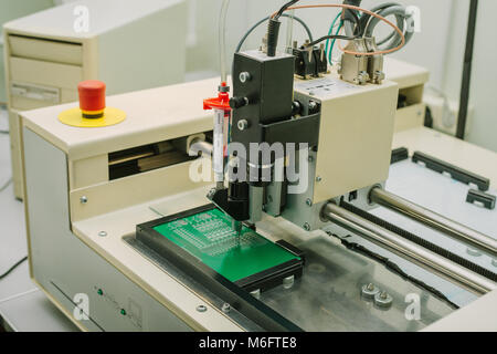 Automazione della macchina di assemblaggio del circuito integrato del computer in fabbrica per la produzione di componenti di un computer. Il processo di saldatura del bordo. La fabbrica per la produzione di microchip. Foto Stock