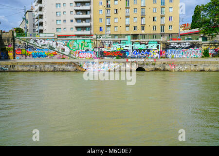 VIENNA, Austria - 4 settembre 2017; Appartamento edifici al di sopra di vandalismo graffiti sui muri costruiti lungo argine del fiume Danubio. Foto Stock