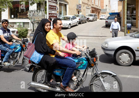 Kashan, Iran - 27 Aprile 2017: uomo musulmano, sua moglie in un hijab e la loro piccola figlia sono in sella a una motocicletta. Foto Stock