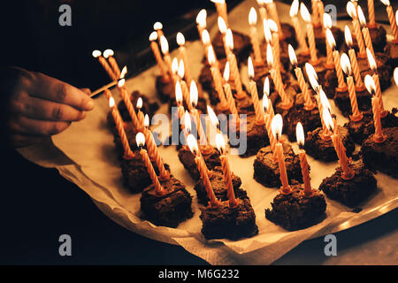 Pezzo di torta con molte candele accese sulla piastra circondato da luci  scintillanti Foto stock - Alamy