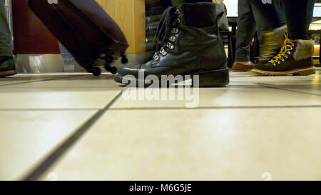 Close-up di gambe umane andando con il bagaglio in aeroporto. Foto Stock