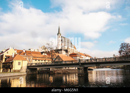 Veduta della chiesa di San Vito e la casa accanto al fiume, un ponte a Cesky Krumlov nella Repubblica Ceca. La chiesa è una delle attrazioni principali della città. Foto Stock