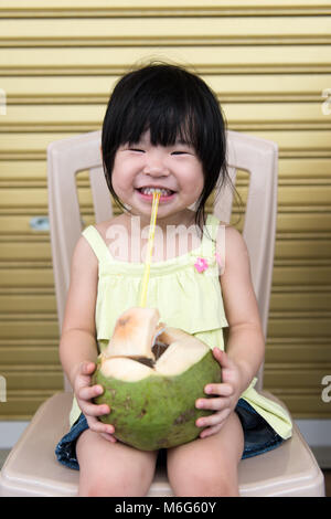 Ragazza carina di bere acqua di cocco Foto Stock