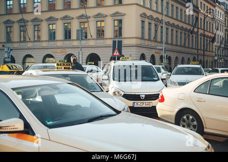 Monaco di Baviera, Germania, Dicembre 29, 2016: Molti tradizionali bavaresi taxi all'Odeonsplatz piazza nel centro di Monaco di Baviera. Trasporto di passeggeri. La vita quotidiana a Monaco di Baviera. Il traffico pesante. Foto Stock